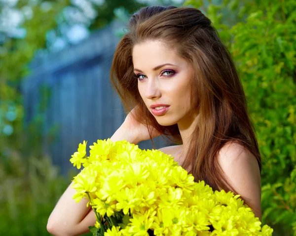 Woman holding yellow flowers . outdoor shoot — Stok fotoğraf
