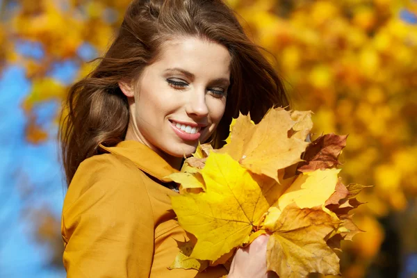 Schöne elegante Frau steht im Herbst in einem Park — Stockfoto