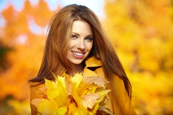 Beautiful elegant woman standing in a park in autumn Stock Photo