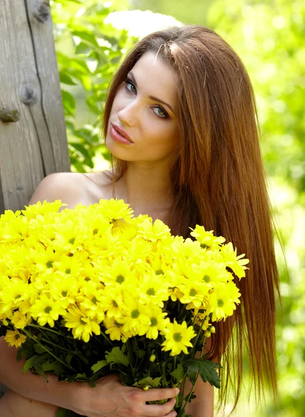 Mujer sosteniendo flores amarillas. disparar al aire libre —  Fotos de Stock