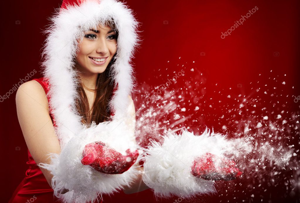 Photo of fashion Christmas girl blowing snow.