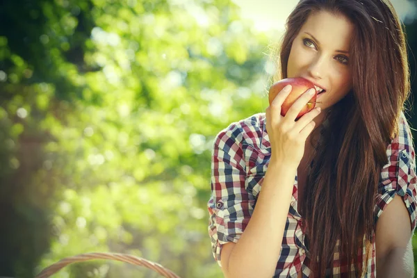 Apple woman. Very beautiful ethnic model eating red apple in the — Stock Photo, Image
