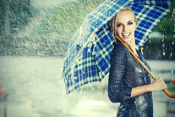 Сексуальная девушка под зонтиком смотрит на дождь — стоковое фото