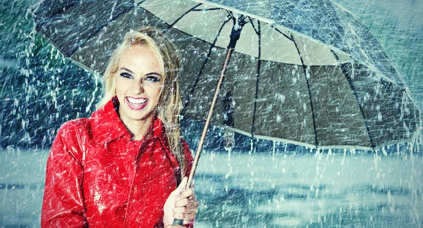 Piękna blond kobieta się trzymając parasol w deszczu — Zdjęcie stockowe