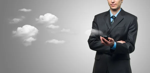 Empresario con teléfono de pantalla táctil y las nubes — Foto de Stock