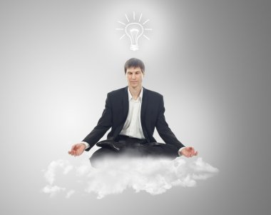 Businessman in lotus position on a cloud with a light bulb over clipart