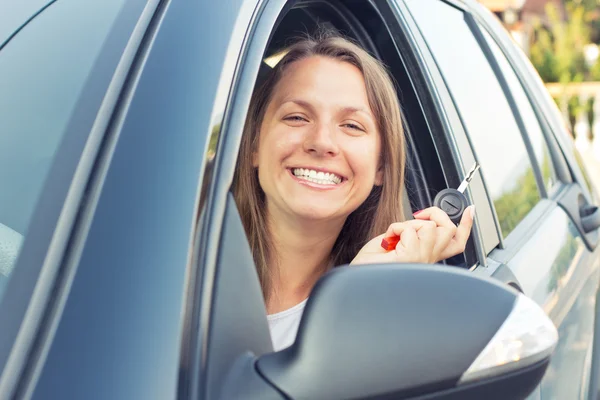 Usměvavá mladá dáma sedící v autě — Stock fotografie