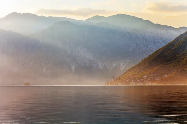 Sunset on the sea with theа foggy mountains — Stock Photo, Image