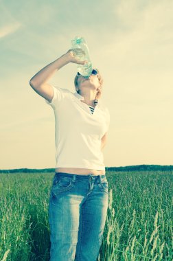 Bir şişe suyu olan genç bir kadın.