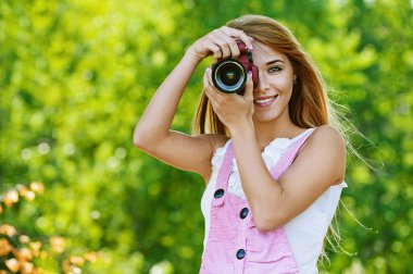 Smiling young woman with camera clipart
