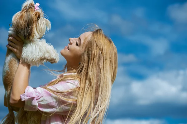 Красивая улыбающаяся молодая женщина с маленькой собачкой — стоковое фото