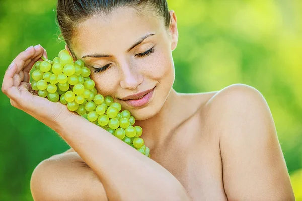Femme aux épaules nues tenant des raisins — Photo
