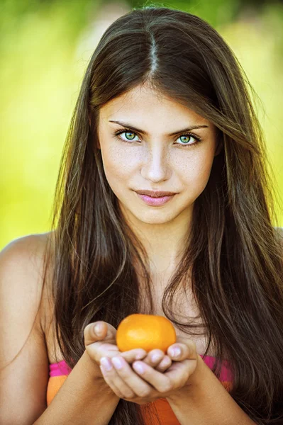 Mulher bonita segurando tangerina — Fotografia de Stock