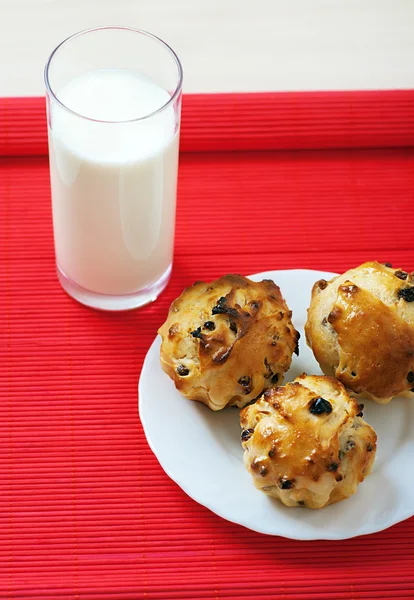 Kleine Muffins auf Teller und Glas Milch — Stockfoto