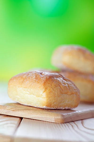 Pães de trigo em tábua de pão — Fotografia de Stock