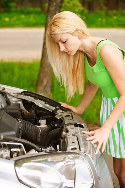 Молода жінка ремонтує машину — стокове фото
