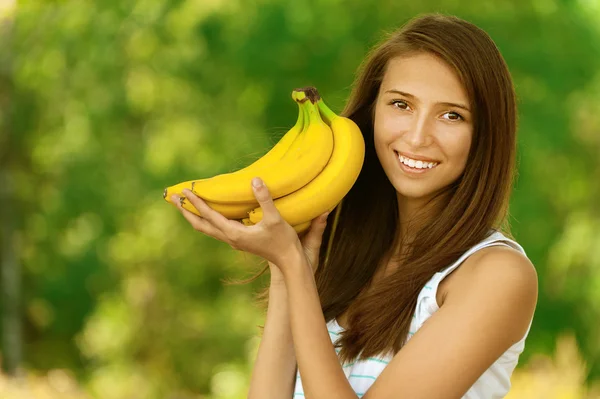 Femme attrayante tenant des bananes — Photo