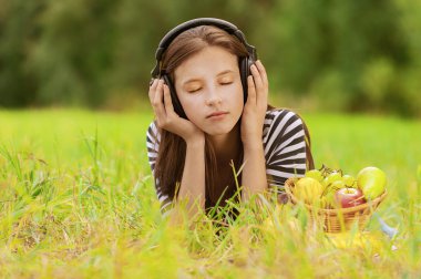 Woman listening to music through headphones clipart