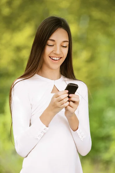 Lächelndes Teenager-Mädchen schreibt SMS — Stockfoto