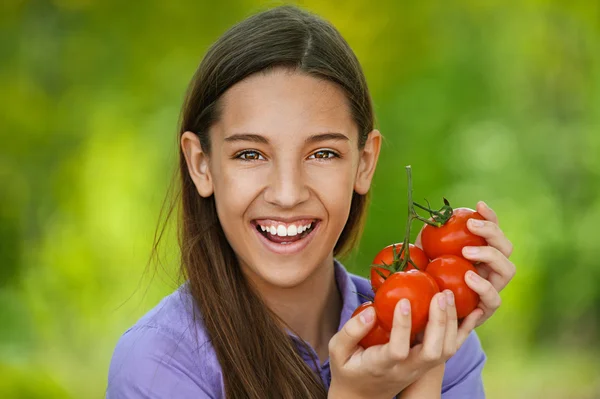 Uśmiechnięte dziewczyny nastoletnie gospodarstwa czerwone pomidory — Zdjęcie stockowe