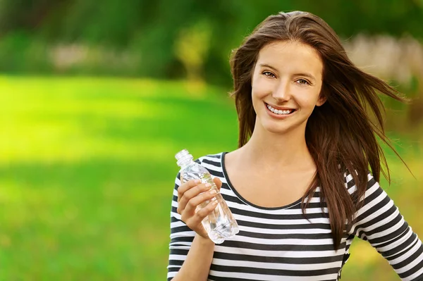 Sonbahar Streamgenç bir kadın tutarak su şişesi — Stok fotoğraf
