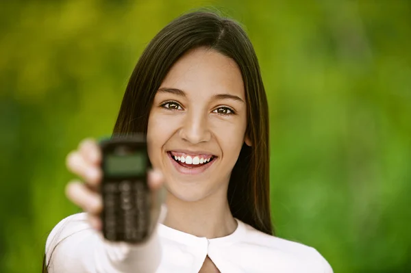 Lachende tienermeisje toont mobiele telefoon — Stockfoto
