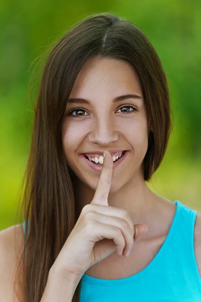 Menina adolescente bonita coloca o dedo em seus lábios — Fotografia de Stock