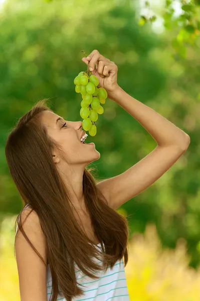 Belle femme mangeant des raisins — Photo