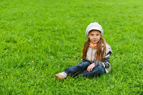 Счастливая девочка-дошкольница на зеленой траве — стоковое фото