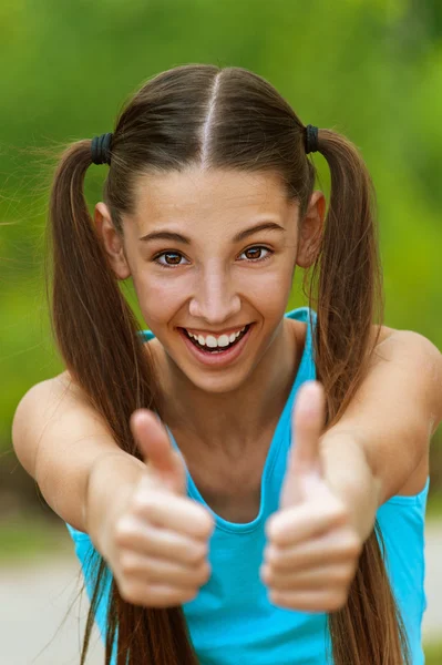Sonriente adolescente recoge grandes pulgares hacia arriba —  Fotos de Stock