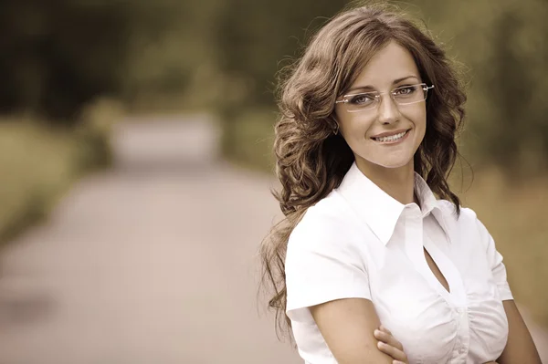 Kvinnan i vit kostym och glasögon leende — Stockfoto