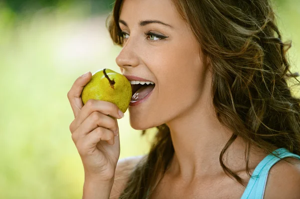 Kvinna närbild i blå skjorta päron bites — Stockfoto