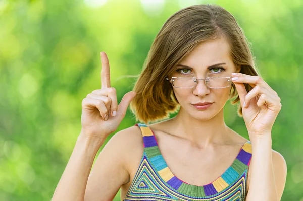 Vrouw uiterlijk vertoon opwaarts met zijn vinger — Stockfoto