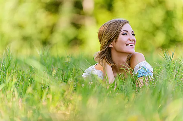 Beautiful young woman in grass — Stock Photo, Image