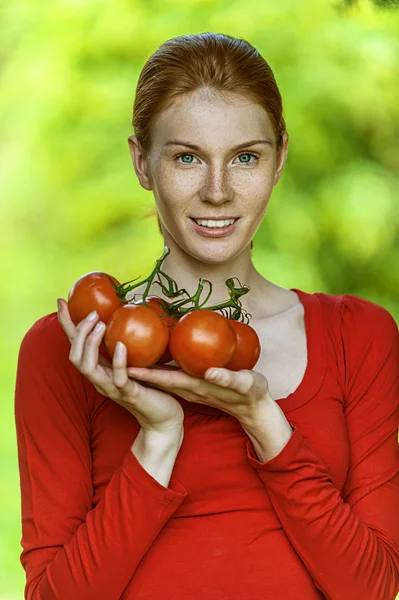 Νεαρή γυναίκα στην κόκκινη μπλούζα με ντομάτα — Φωτογραφία Αρχείου