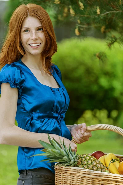 Ung kvinna med korgar av frukt och grönsaker — Stockfoto