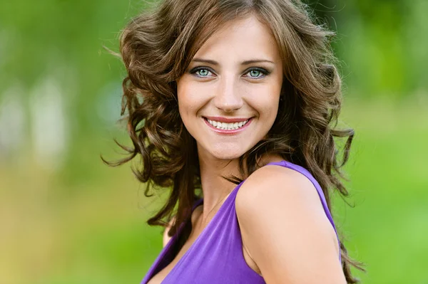 Fiatal nő, lila ruhában, boldogan mosolygó — Stock Fotó