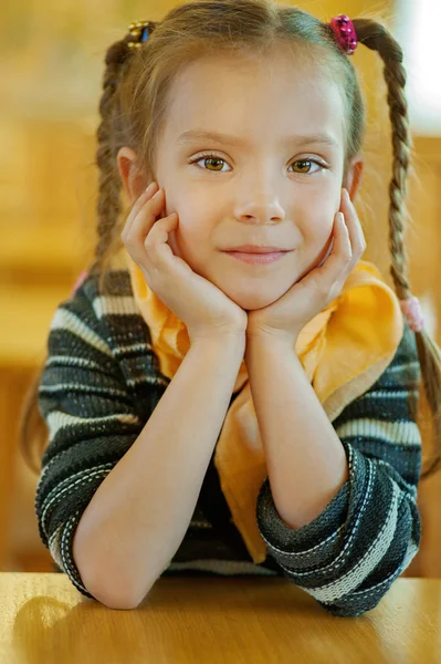 Дівчина-дошкільник сидить за столом — стокове фото