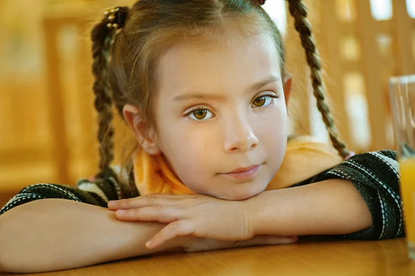 Дівчина-дошкільник сидить за столом — стокове фото