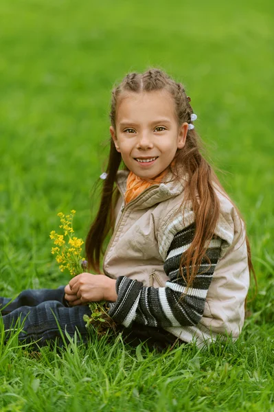 Yeşil çimenlerin üzerinde mutlu kız-okul öncesi — Stok fotoğraf