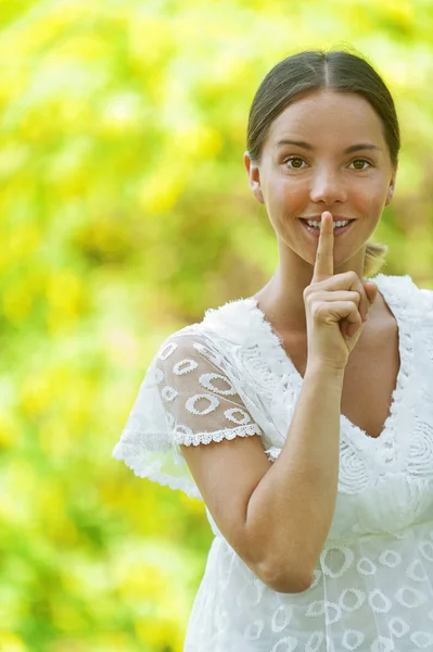 Młoda kobieta kładzie palec na ustach — Zdjęcie stockowe
