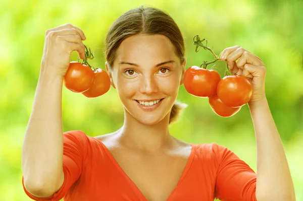 Mladá žena v červené halence s rajčaty — Stock fotografie