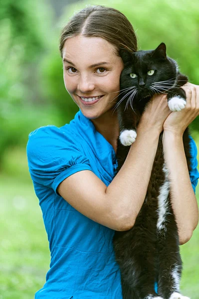 Молодая женщина с черной кошкой — стоковое фото