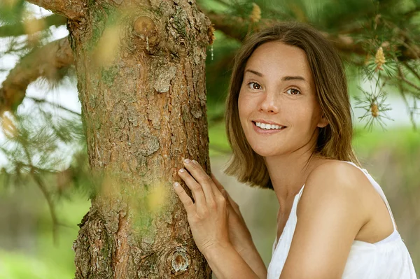 Jeune femme près du tronc arbre — Photo