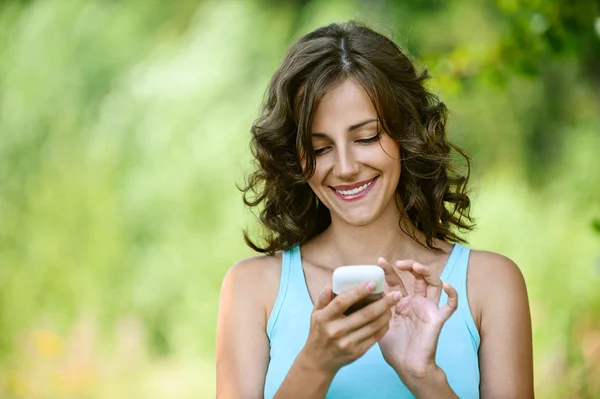 Frau liest Nachricht auf Handy vor lizenzfreie Stockbilder