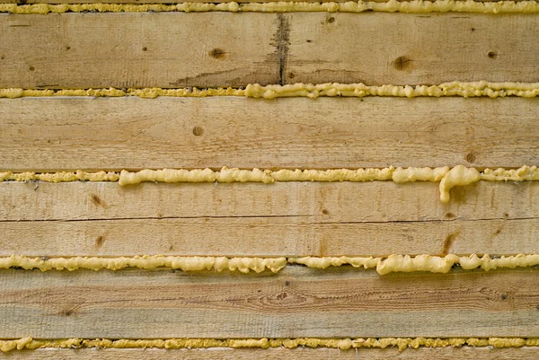 Zbliżenie: pianka poliuretanowa, wypełnienie luki w konstrukcji drewnianej — Zdjęcie stockowe
