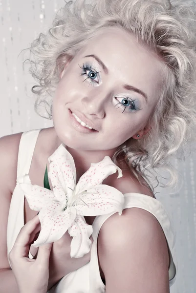 Piękna młoda kobieta z oryginalnego makijażu i kwiat — Zdjęcie stockowe