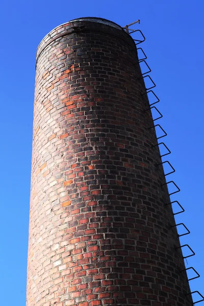 Old brick chimney on blue sky — Stock Photo, Image