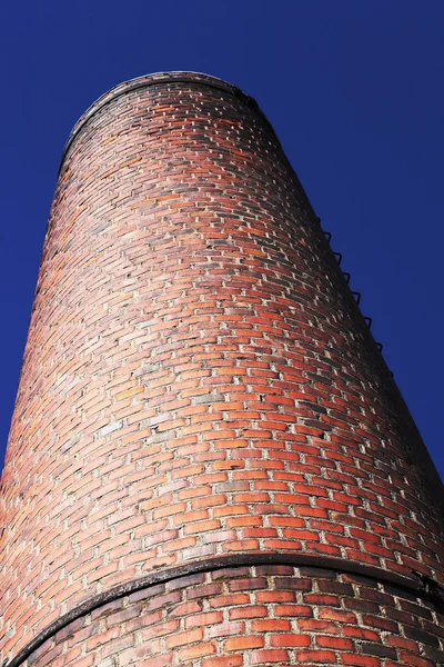 Brick chimney on blue sky background — Stock Photo, Image