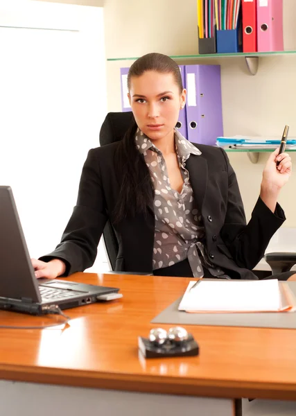 Ділова жінка сидить в офісі перед ноутбуком — стокове фото